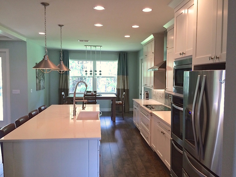 Idéer för ett mellanstort modernt linjärt kök med öppen planlösning, med en undermonterad diskho, luckor med infälld panel, vita skåp, bänkskiva i kvarts, vitt stänkskydd, stänkskydd i glaskakel, rostfria vitvaror och en köksö