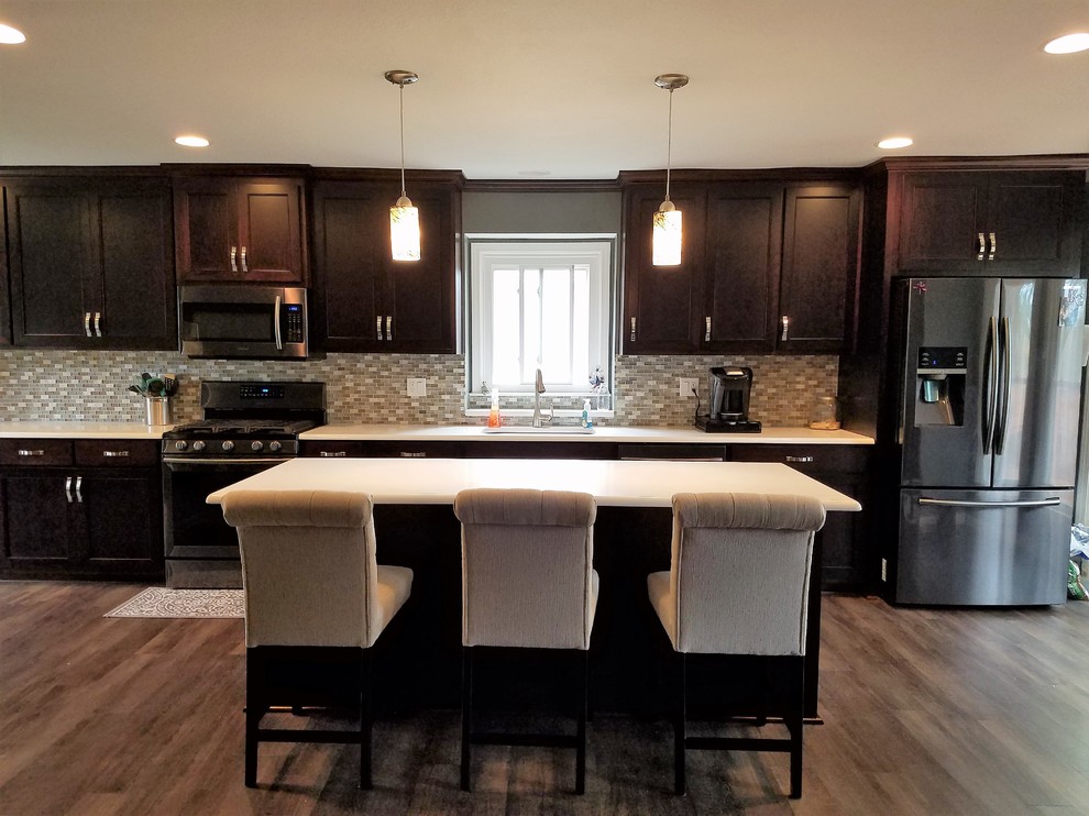 Large elegant single-wall dark wood floor and brown floor open concept kitchen photo in Kansas City with an undermount sink, shaker cabinets, dark wood cabinets, quartz countertops, gray backsplash, glass tile backsplash, stainless steel appliances, an island and white countertops