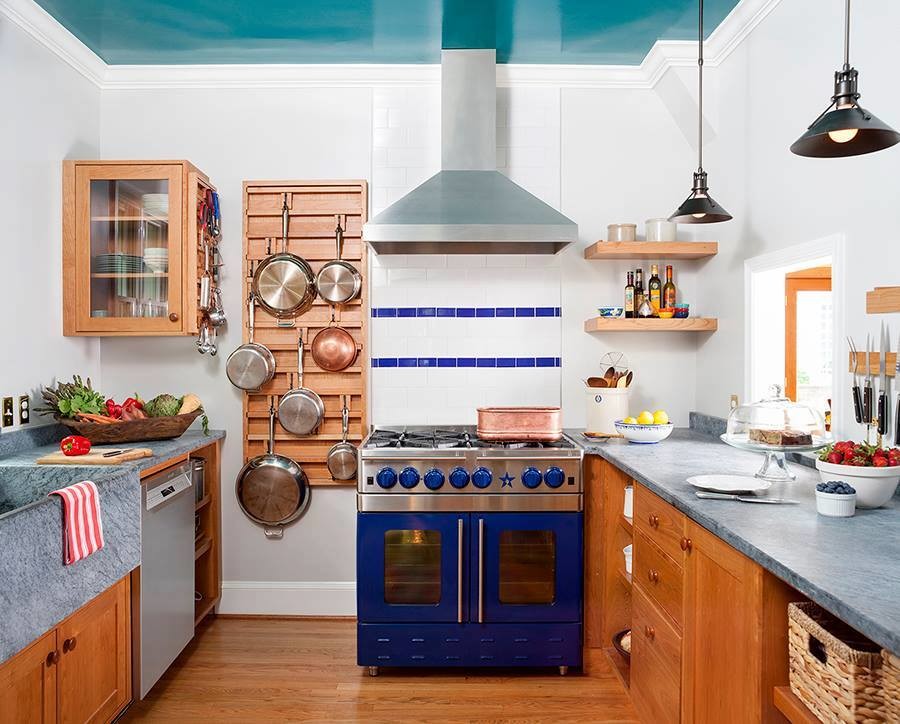 Mid-sized southwest u-shaped dark wood floor and brown floor eat-in kitchen photo in Boston with a farmhouse sink, recessed-panel cabinets, brown cabinets, limestone countertops, white backsplash, subway tile backsplash, colored appliances, a peninsula and gray countertops