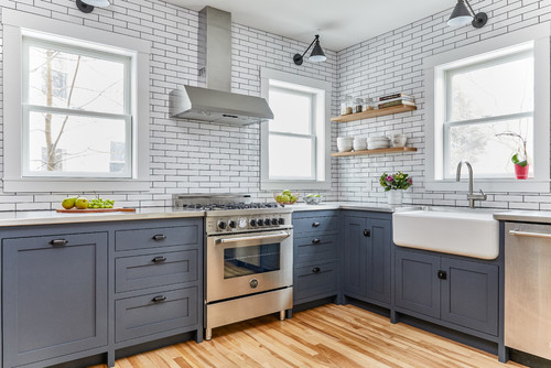 Modern farmhouse kitchen with navy blue cabinets, white subway tile backsplash, and stainless appliances, showcasing DIY Trend with RTA Cabinets in Canada.