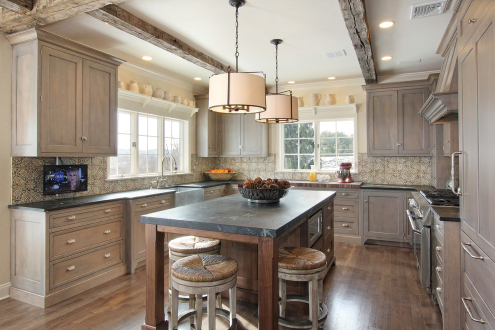 Rustic u-shaped kitchen/diner in Philadelphia with a belfast sink, recessed-panel cabinets, grey cabinets, stainless steel appliances, medium hardwood flooring and multi-coloured splashback.