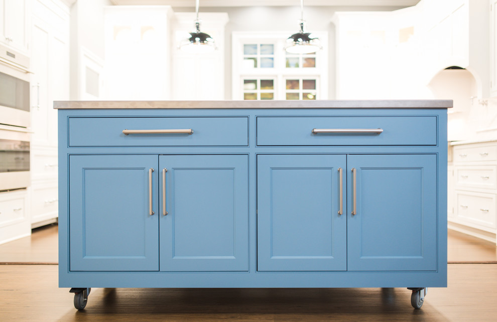 Moderne Küche mit Kassettenfronten, blauen Schränken, Edelstahl-Arbeitsplatte und Kücheninsel in Sonstige