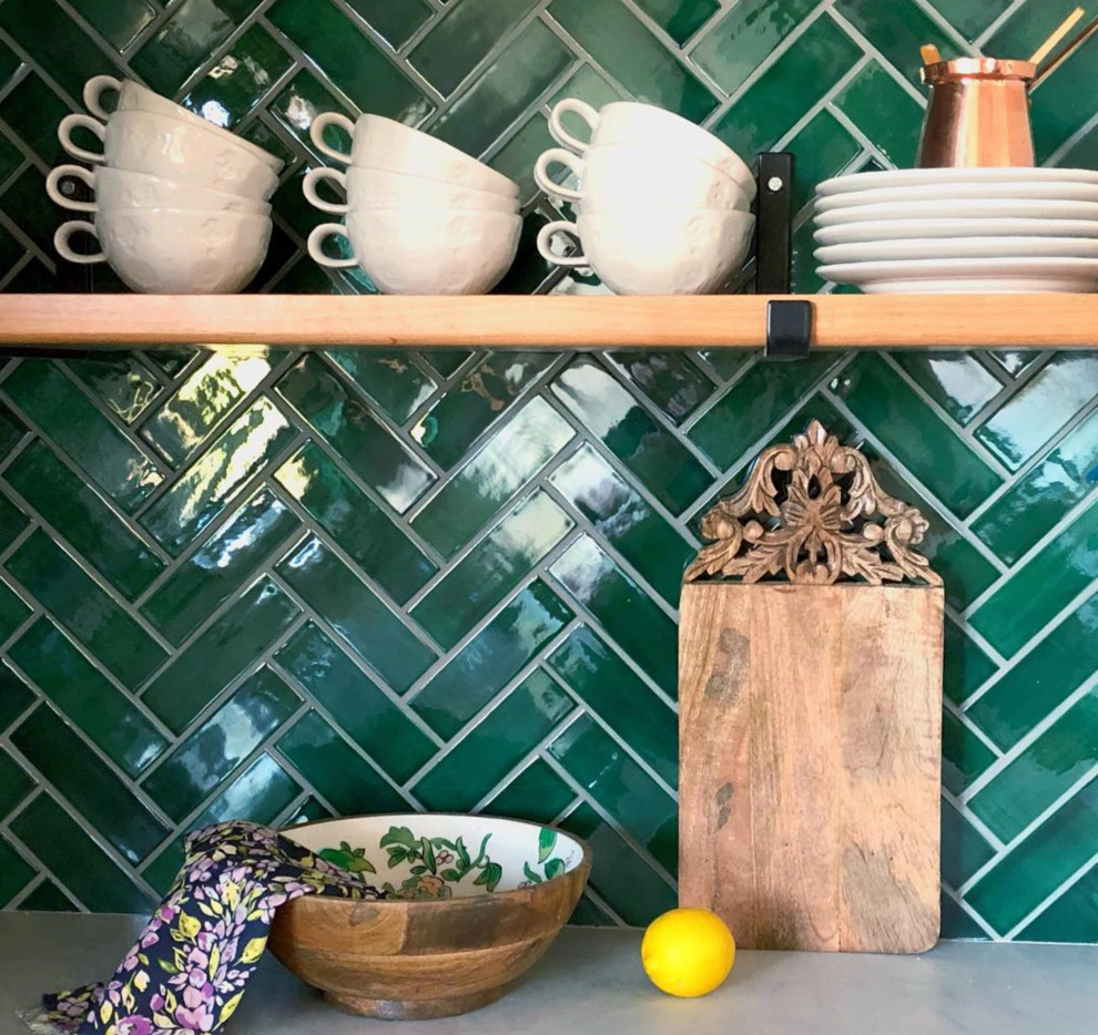 Foto på ett grå kök, med stänkskydd i keramik