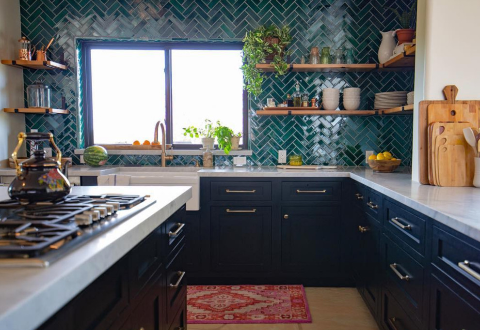 Réalisation d'une cuisine en U avec des portes de placard noires, une crédence verte, une crédence en céramique, îlot, un sol beige et un plan de travail blanc.