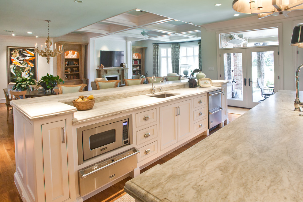 Large elegant l-shaped medium tone wood floor and brown floor eat-in kitchen photo in Dallas with an undermount sink, shaker cabinets, white cabinets, quartz countertops, green backsplash, glass tile backsplash, stainless steel appliances and two islands