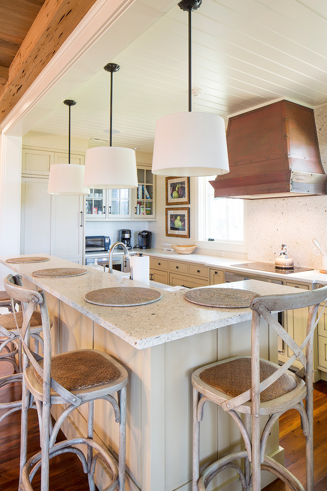 Example of a cottage u-shaped kitchen design in Philadelphia with recessed-panel cabinets and an island