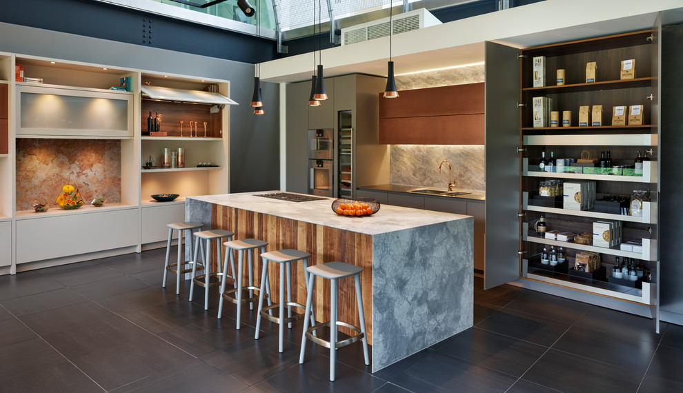 Inspiration för ett mycket stort funkis grå linjärt grått kök med öppen planlösning, med släta luckor, beige skåp, marmorbänkskiva, beige stänkskydd, glaspanel som stänkskydd, integrerade vitvaror, klinkergolv i keramik, en köksö och svart golv