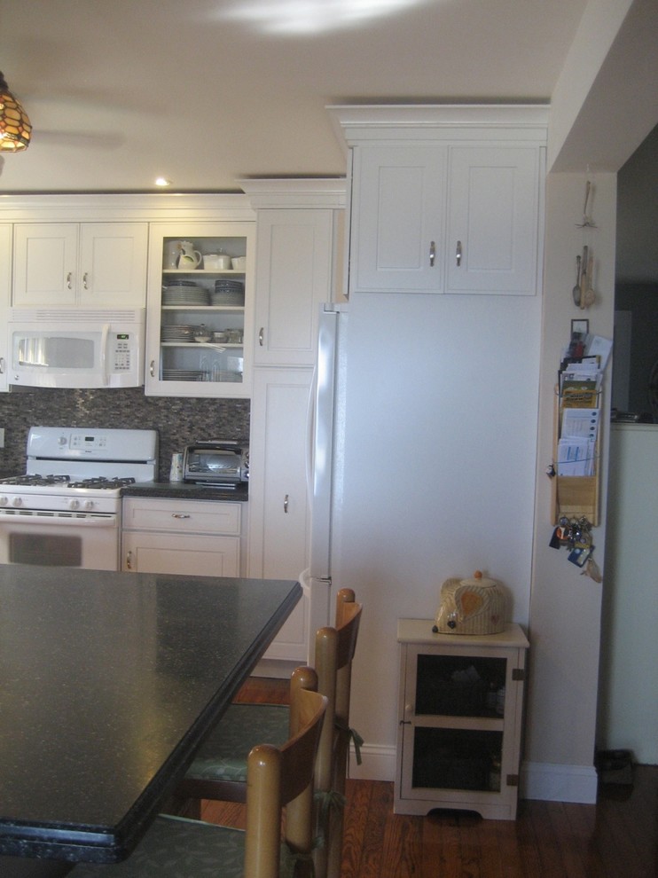 Exempel på ett litet lantligt kök, med en undermonterad diskho, luckor med infälld panel, vita skåp, bänkskiva i kvarts, beige stänkskydd, stänkskydd i porslinskakel, vita vitvaror, ljust trägolv och en köksö