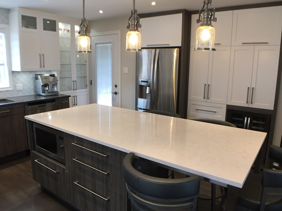 Bild på ett mellanstort funkis vit vitt kök, med en dubbel diskho, skåp i shakerstil, vita skåp, bänkskiva i kvartsit, vitt stänkskydd, glaspanel som stänkskydd, rostfria vitvaror, klinkergolv i porslin, en köksö och grått golv