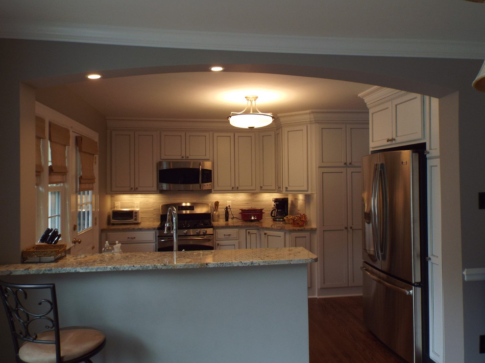 Foto de cocina comedor clásica con fregadero bajoencimera, armarios con paneles lisos, puertas de armario blancas, encimera de granito y electrodomésticos de acero inoxidable