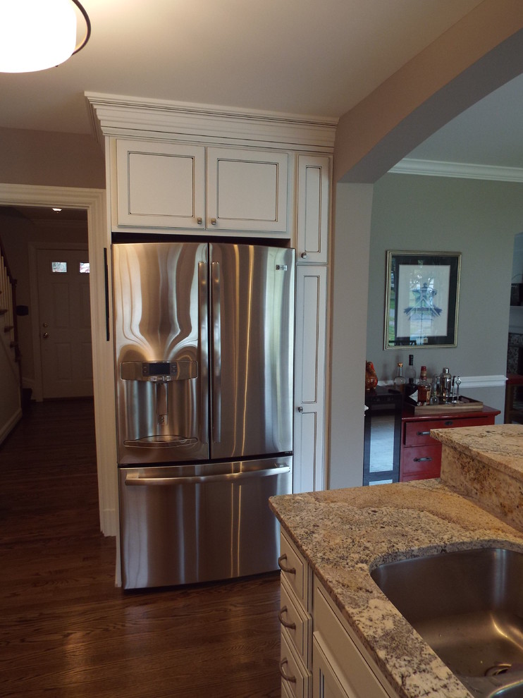 Exempel på ett klassiskt kök och matrum, med en undermonterad diskho, släta luckor, vita skåp, granitbänkskiva och rostfria vitvaror