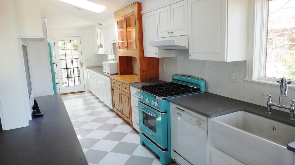 Inspiration for a mid-sized coastal galley kitchen pantry remodel in Other with a farmhouse sink, raised-panel cabinets, white cabinets, quartz countertops, white backsplash, subway tile backsplash, colored appliances and a peninsula