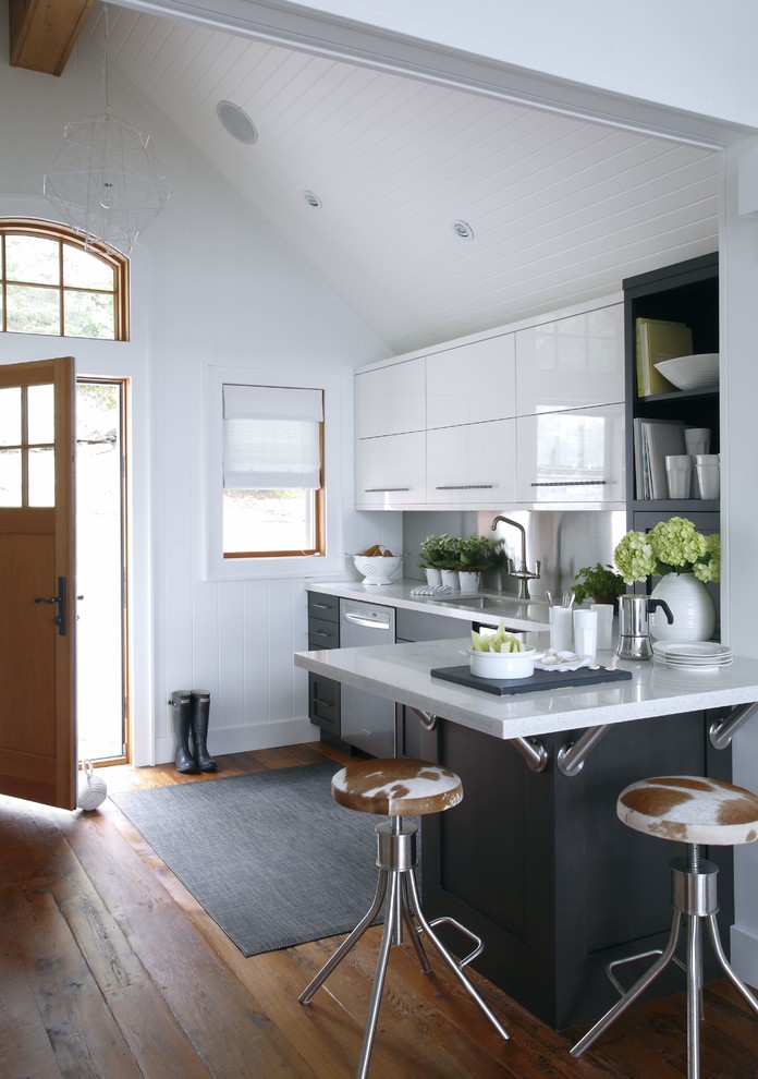 Exempel på ett litet klassiskt kök, med släta luckor, vita skåp, stänkskydd med metallisk yta, rostfria vitvaror, mellanmörkt trägolv, en halv köksö, brunt golv och en undermonterad diskho