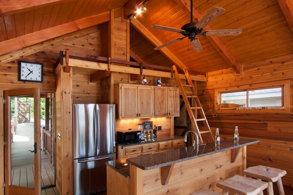 Bild på ett mellanstort rustikt kök, med luckor med infälld panel, rostfria vitvaror, skåp i ljust trä, granitbänkskiva, stänkskydd i trä, mellanmörkt trägolv och en köksö