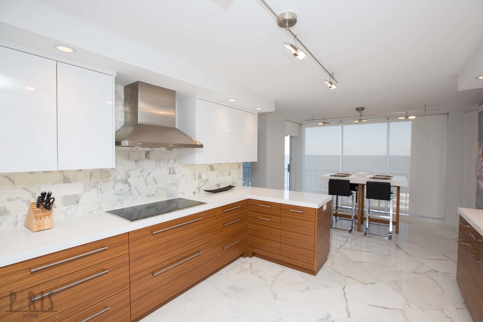 This is an example of a large contemporary kitchen/diner in Miami with a belfast sink, flat-panel cabinets, medium wood cabinets, quartz worktops, white splashback, stainless steel appliances, marble flooring and an island.