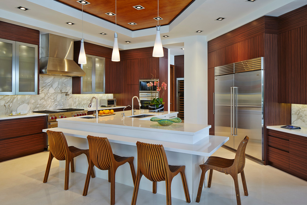Moderne Küche in U-Form mit Unterbauwaschbecken, flächenbündigen Schrankfronten, Küchenrückwand in Grau, Küchengeräten aus Edelstahl und Kücheninsel in Miami