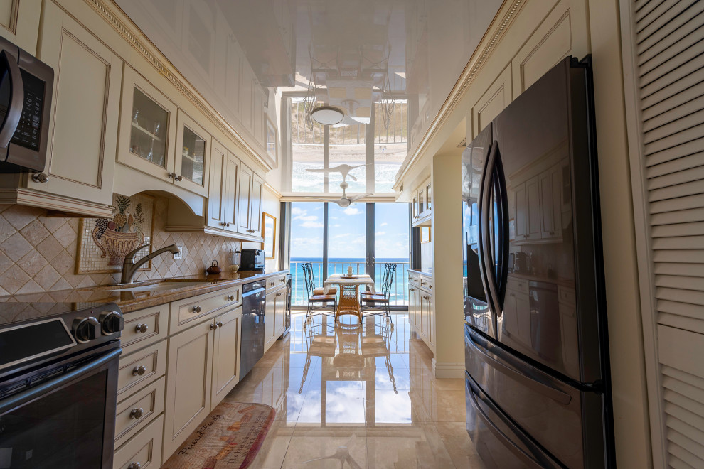 Large classic galley enclosed kitchen in Miami with a single-bowl sink, recessed-panel cabinets, beige cabinets, granite worktops, beige splashback, ceramic splashback, black appliances, marble flooring, no island, beige floors, orange worktops and a wallpapered ceiling.