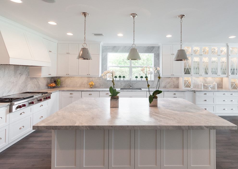 Large minimalist porcelain tile kitchen photo in Miami with a drop-in sink, raised-panel cabinets, white cabinets, marble countertops, multicolored backsplash, stone slab backsplash, stainless steel appliances and an island
