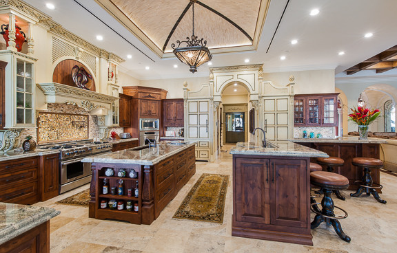 Immagine di una cucina classica con lavello sottopiano, paraspruzzi con piastrelle in pietra, elettrodomestici in acciaio inossidabile e pavimento in travertino