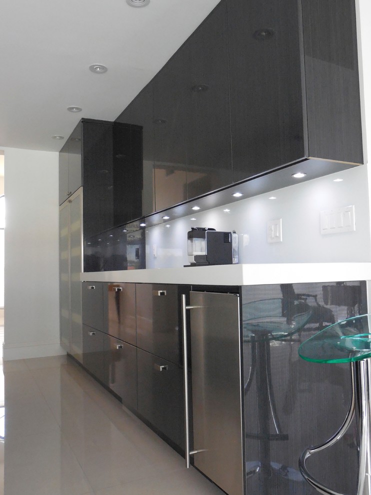 Moderne Wohnküche mit Quarzwerkstein-Arbeitsplatte, Küchenrückwand in Weiß, Glasrückwand und Küchengeräten aus Edelstahl in Miami