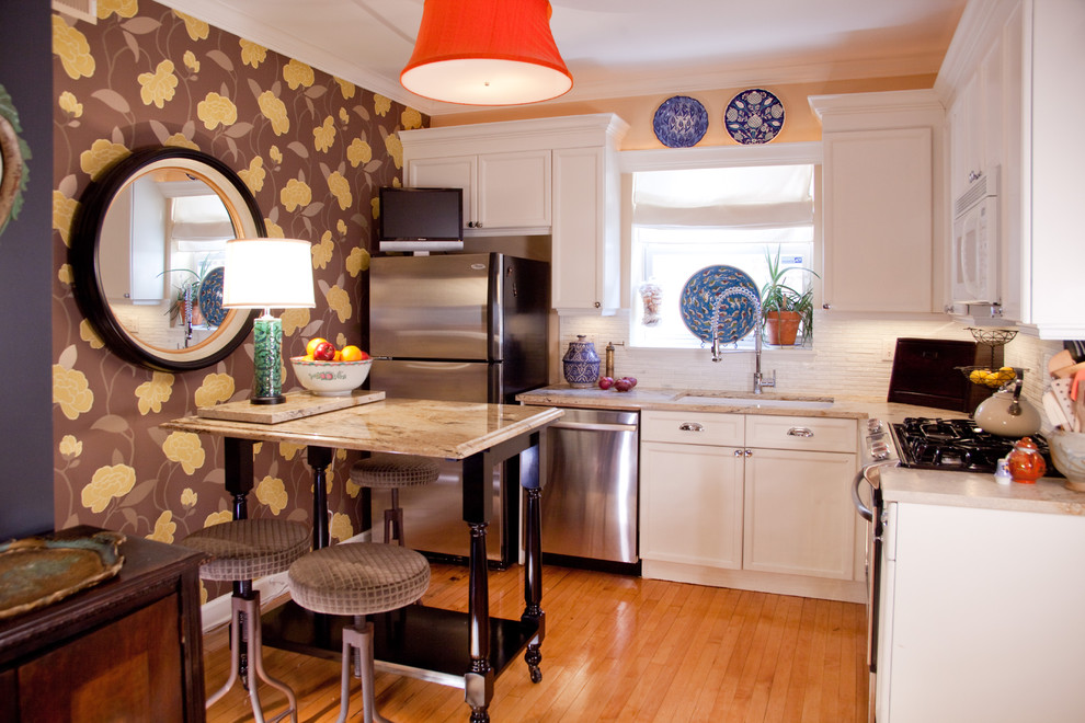 Bild på ett eklektiskt l-kök, med en undermonterad diskho, luckor med infälld panel, vita skåp, vitt stänkskydd och rostfria vitvaror