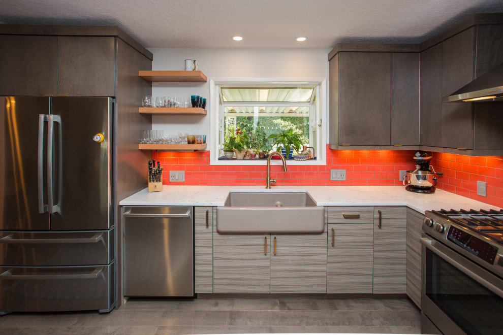 Mid-sized eclectic u-shaped medium tone wood floor and brown floor eat-in kitchen photo in Portland with a farmhouse sink, flat-panel cabinets, medium tone wood cabinets, quartz countertops, red backsplash, subway tile backsplash, stainless steel appliances, an island and white countertops