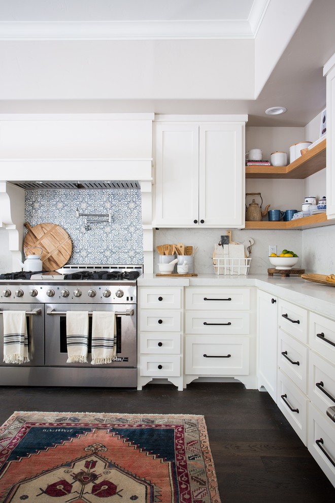 Example of a transitional l-shaped dark wood floor and brown floor kitchen design in Sacramento with shaker cabinets, white cabinets, white backsplash, stainless steel appliances and white countertops