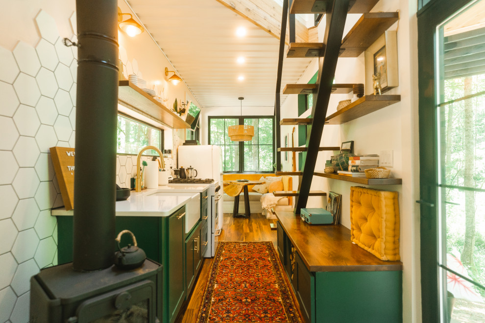 コロンバスにあるカントリー風のおしゃれなII型キッチン (エプロンフロントシンク、シェーカースタイル扉のキャビネット、緑のキャビネット、白いキッチンパネル、濃色無垢フローリング、茶色い床、白いキッチンカウンター) の写真