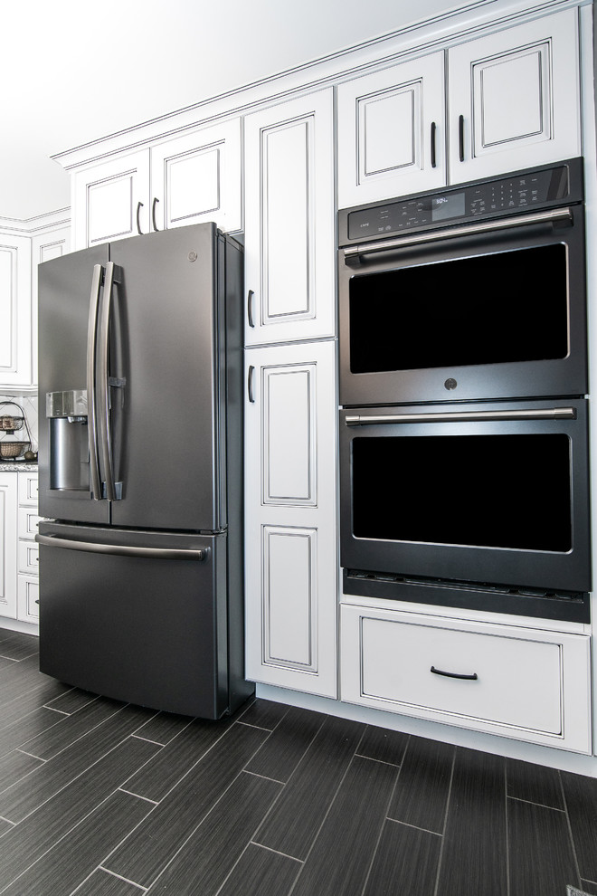 Inspiration for a large modern l-shaped porcelain tile and black floor eat-in kitchen remodel in Bridgeport with an undermount sink, raised-panel cabinets, white cabinets, white backsplash, ceramic backsplash, black appliances, an island and multicolored countertops