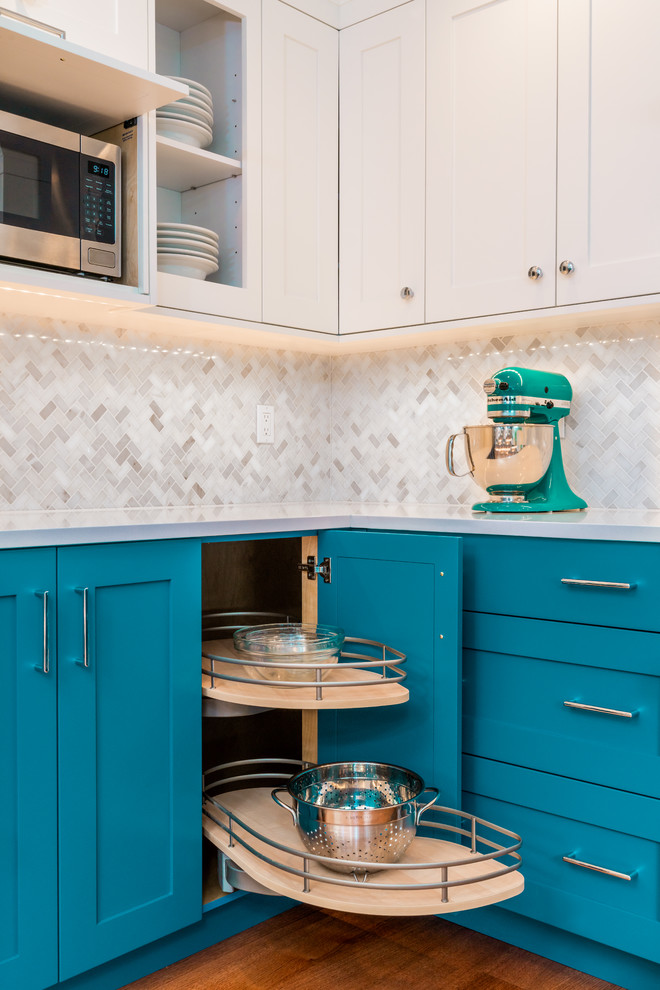This is an example of a small classic u-shaped kitchen pantry in Seattle with a submerged sink, shaker cabinets, blue cabinets, engineered stone countertops, white splashback, marble splashback, stainless steel appliances, light hardwood flooring and white worktops.