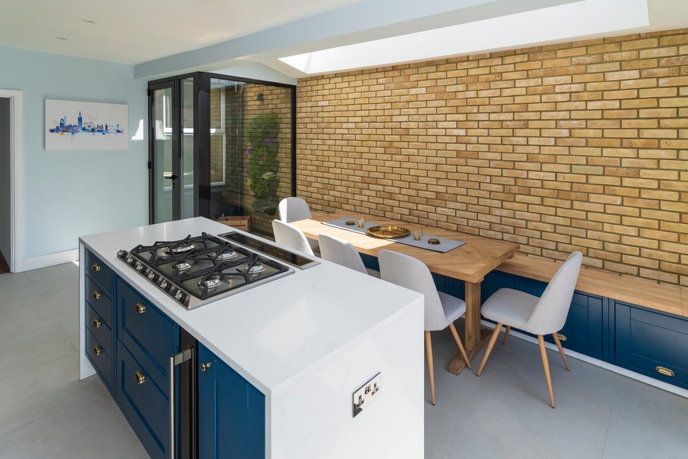 Zweizeilige Moderne Wohnküche mit Landhausspüle, Schrankfronten mit vertiefter Füllung, blauen Schränken, Küchenrückwand in Weiß, Zementfliesen für Boden, Kücheninsel, grauem Boden und weißer Arbeitsplatte in Sussex
