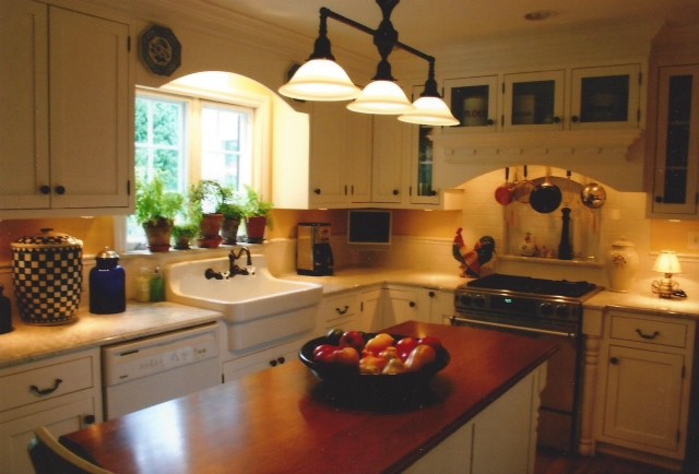 Foto på ett lantligt kök och matrum, med en rustik diskho, luckor med infälld panel, vita skåp, granitbänkskiva, beige stänkskydd, rostfria vitvaror och en köksö