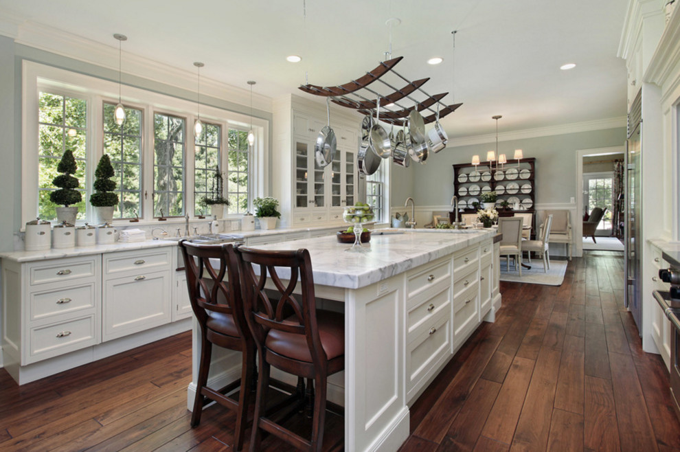 Exempel på ett stort klassiskt kök, med en rustik diskho, skåp i shakerstil, vita skåp, marmorbänkskiva, rostfria vitvaror, mörkt trägolv, en köksö och brunt golv
