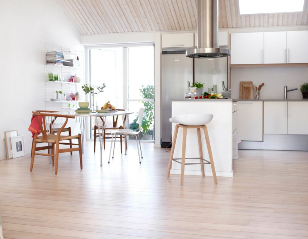 Foto di una cucina abitabile scandinava con ante lisce, ante bianche, top in quarzite, elettrodomestici in acciaio inossidabile, parquet chiaro e penisola