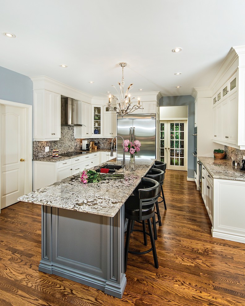 Enclosed kitchen - large transitional u-shaped medium tone wood floor and brown floor enclosed kitchen idea in Toronto with a double-bowl sink, white cabinets, granite countertops, stainless steel appliances, an island, shaker cabinets, multicolored backsplash and stone slab backsplash