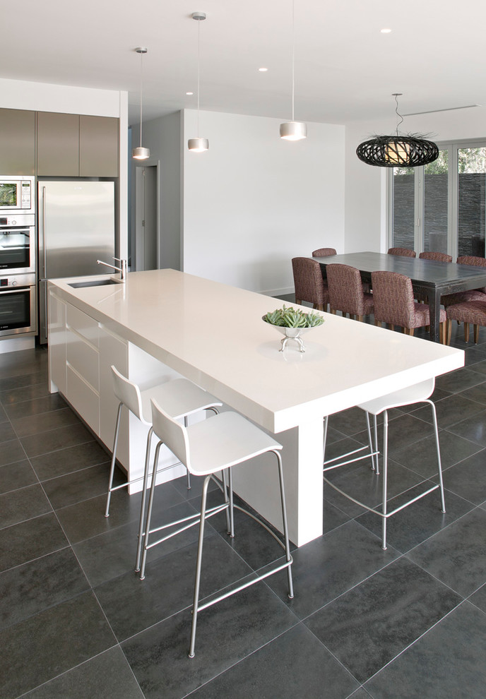Inspiration for a medium sized contemporary l-shaped kitchen/diner in Sydney with a submerged sink, flat-panel cabinets, white cabinets, quartz worktops, white splashback, glass sheet splashback, stainless steel appliances, porcelain flooring and an island.