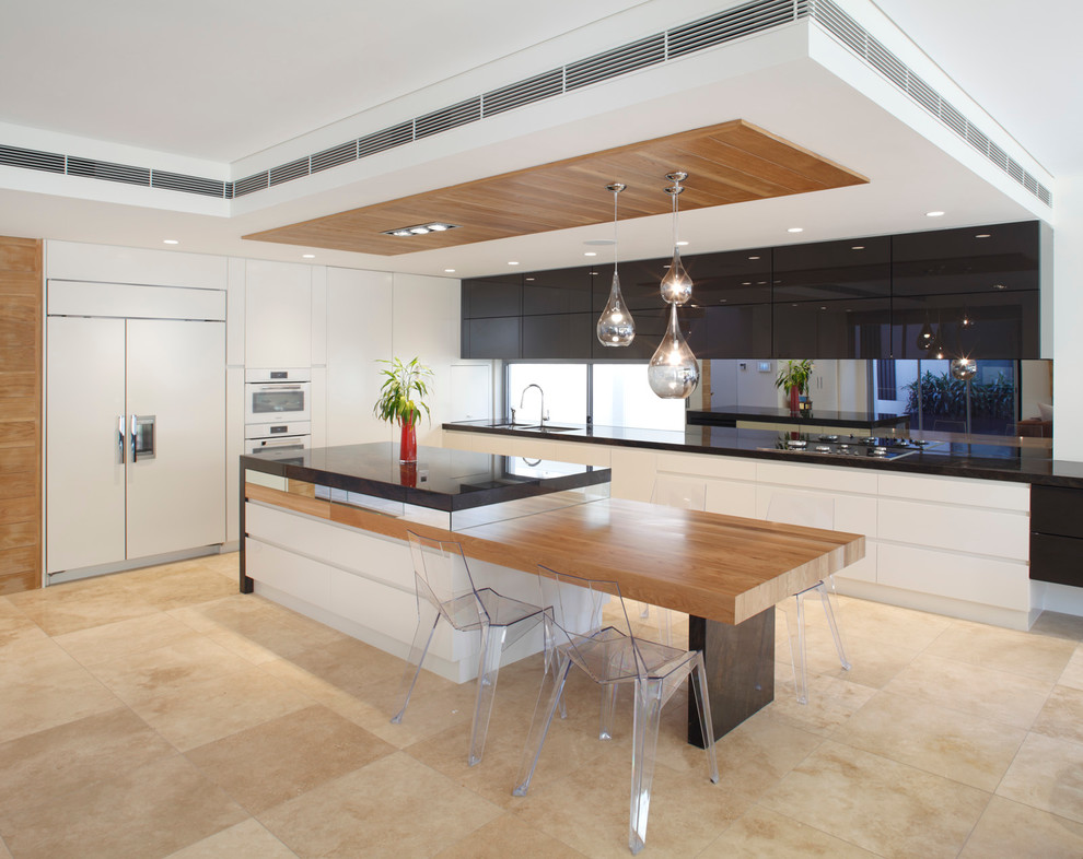 Moderne Küche mit flächenbündigen Schrankfronten, weißen Schränken, Travertin, Kücheninsel und Elektrogeräten mit Frontblende in Sydney
