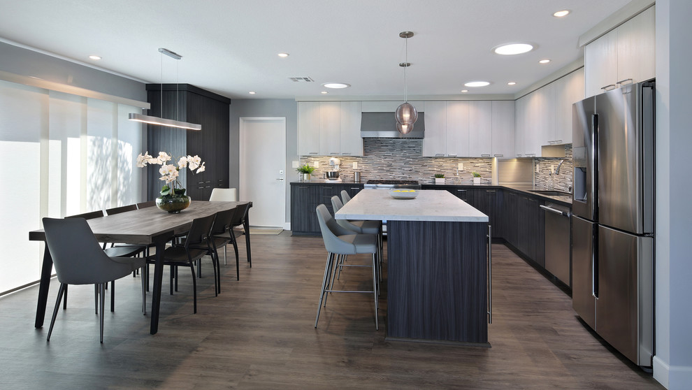 Eat-in kitchen - mid-sized contemporary l-shaped gray floor and laminate floor eat-in kitchen idea in Orange County with flat-panel cabinets, gray cabinets, porcelain backsplash, stainless steel appliances, an island, an undermount sink, quartz countertops and multicolored backsplash