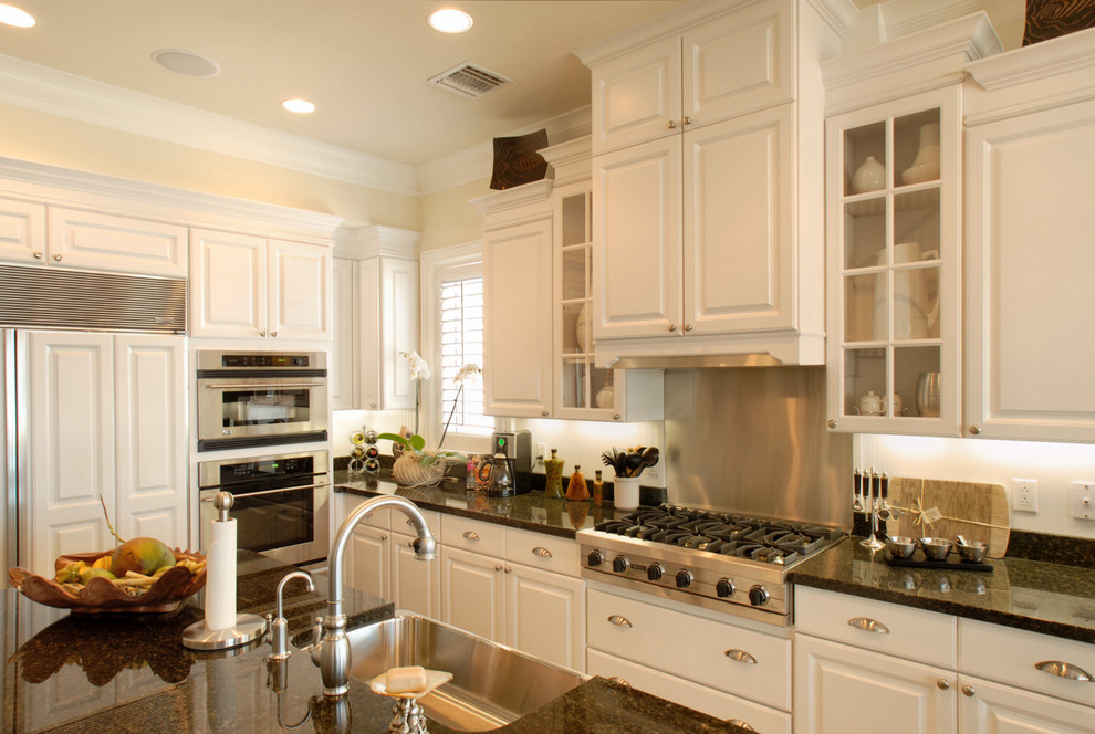 Large elegant kitchen photo in Miami with paneled appliances, granite countertops, a farmhouse sink, raised-panel cabinets and white cabinets