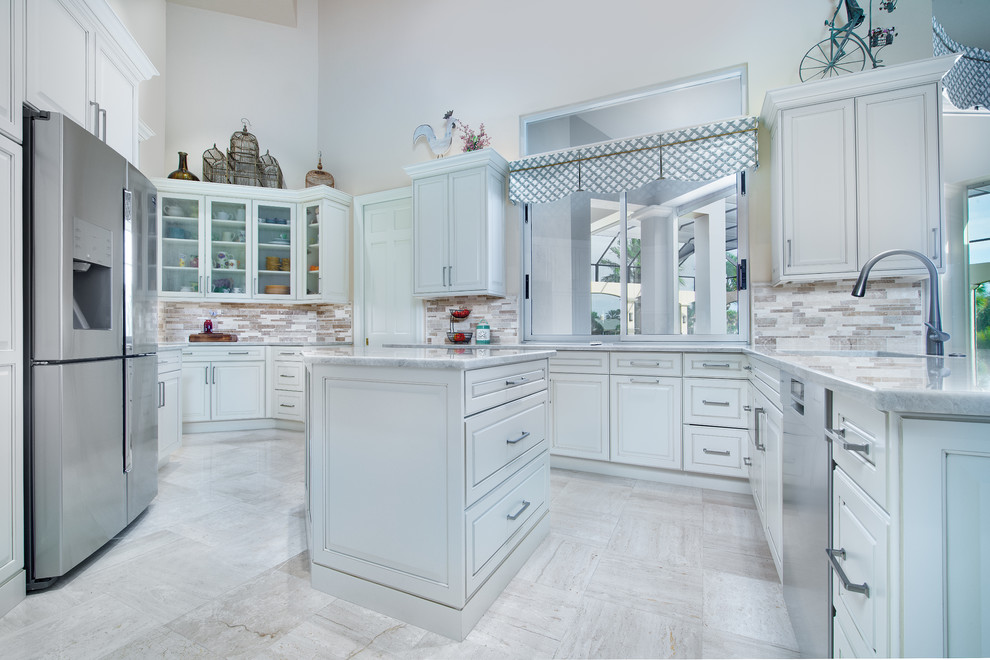 Inspiration for a large traditional l-shaped open plan kitchen in Miami with a submerged sink, raised-panel cabinets, white cabinets, quartz worktops, multi-coloured splashback, stone tiled splashback, stainless steel appliances, an island and white worktops.