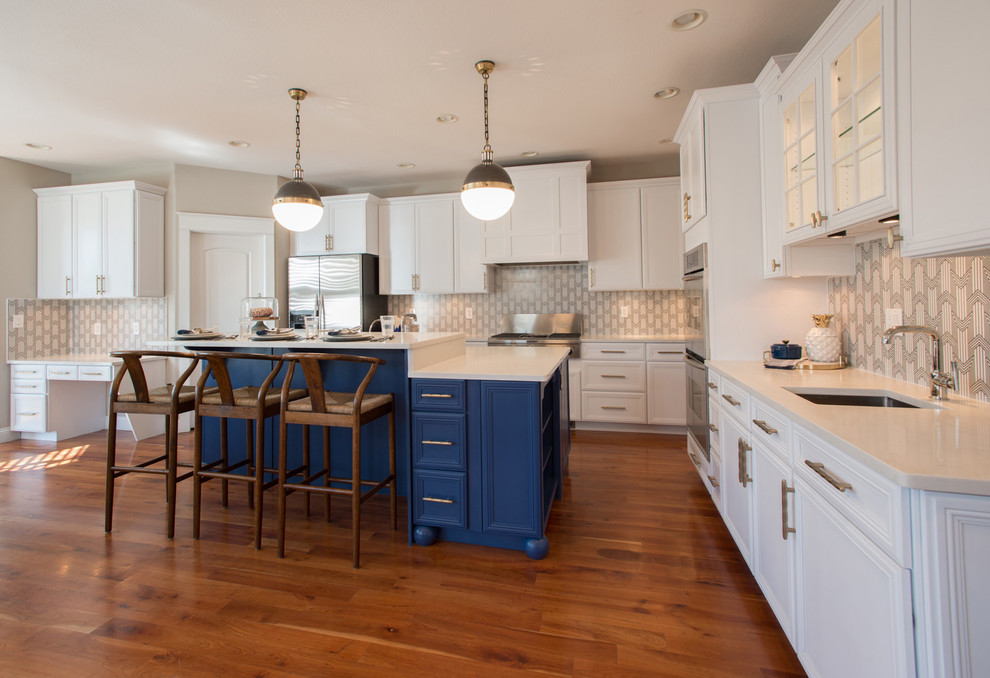 Bild på ett mellanstort eklektiskt kök, med en undermonterad diskho, skåp i shakerstil, vita skåp, bänkskiva i kvarts, flerfärgad stänkskydd, stänkskydd i cementkakel, rostfria vitvaror, mellanmörkt trägolv, en köksö och brunt golv