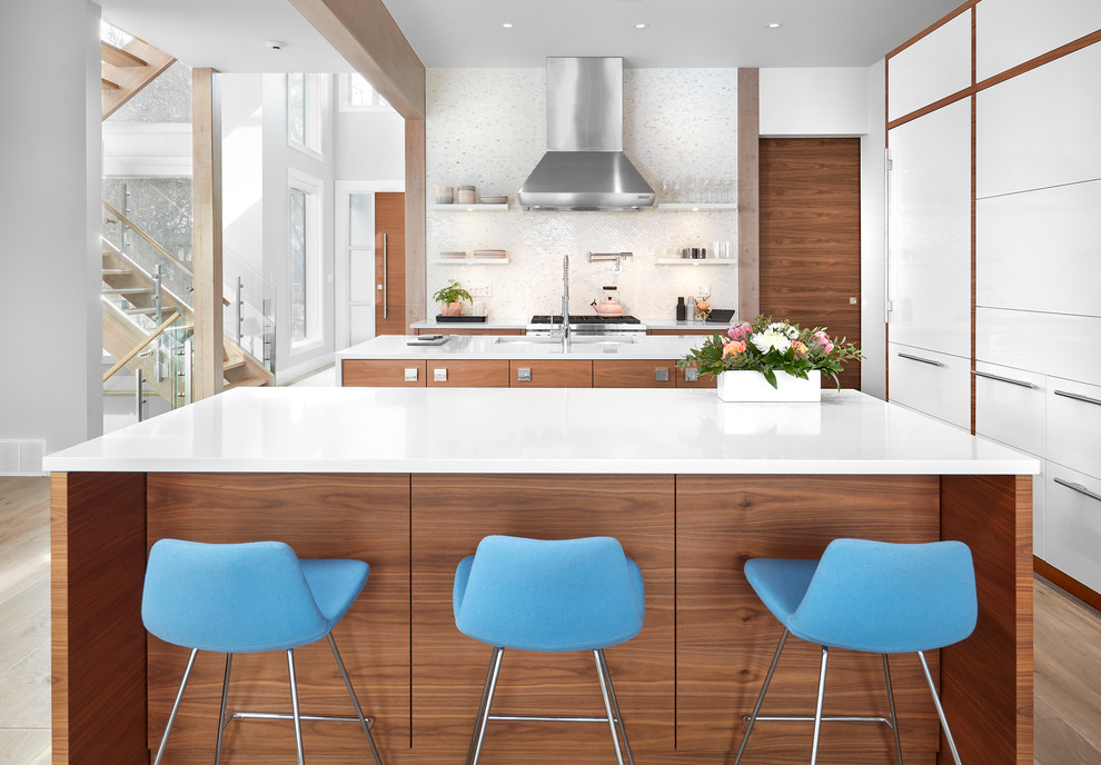 Bild på ett funkis kök, med släta luckor, vita skåp, stänkskydd med metallisk yta, integrerade vitvaror och flera köksöar