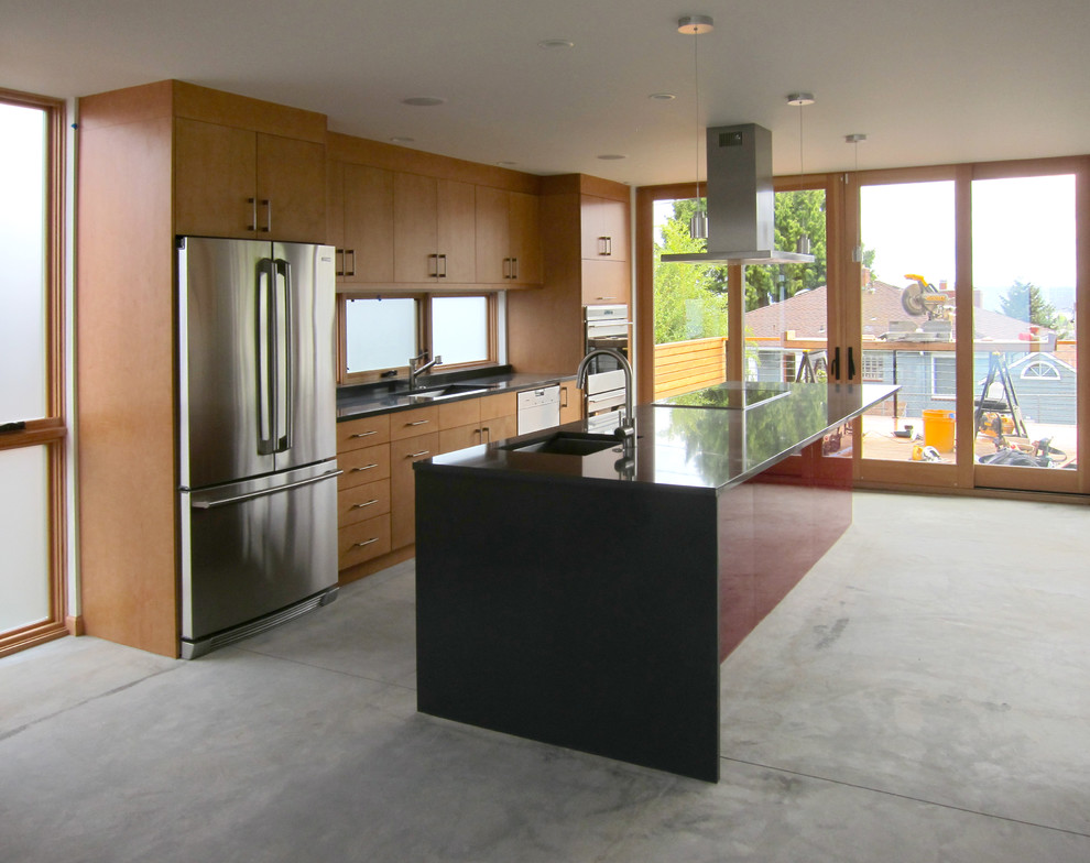 Esempio di una cucina minimalista con lavello sottopiano, ante lisce, top in granito e elettrodomestici in acciaio inossidabile