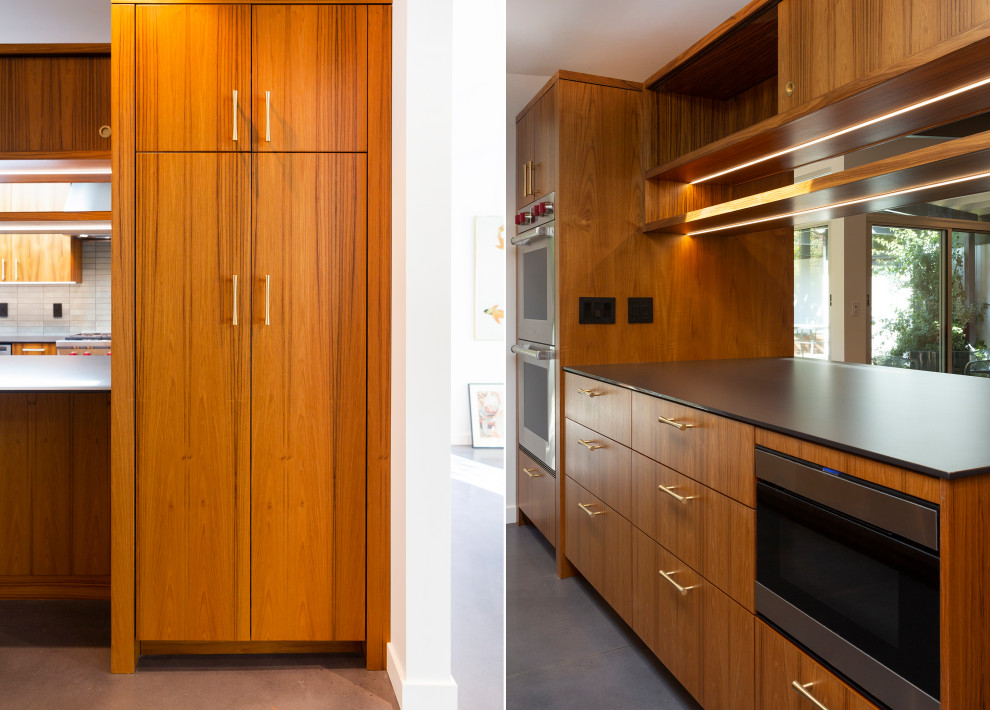 Esempio di una cucina minimalista di medie dimensioni con ante lisce, ante in legno scuro, elettrodomestici in acciaio inossidabile, pavimento in cemento, pavimento grigio e top nero