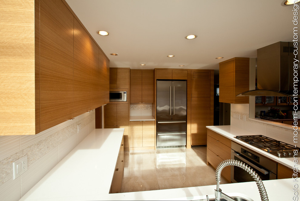 Bild på ett avskilt, mellanstort funkis u-kök, med en undermonterad diskho, släta luckor, skåp i ljust trä, bänkskiva i kvartsit, vitt stänkskydd, rostfria vitvaror och marmorgolv