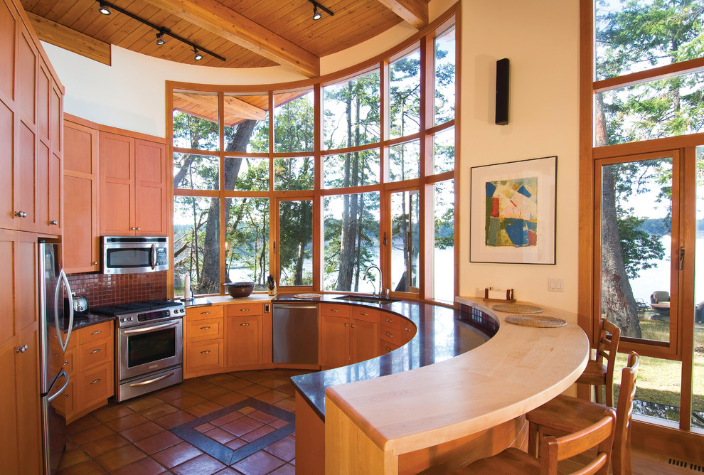 Example of a trendy u-shaped terra-cotta tile and orange floor open concept kitchen design in Vancouver with an undermount sink, shaker cabinets, medium tone wood cabinets, red backsplash, mosaic tile backsplash, stainless steel appliances and a peninsula