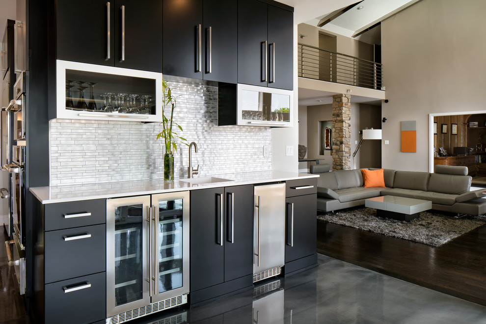 Design ideas for a large contemporary galley kitchen/diner in Charlotte with an integrated sink, flat-panel cabinets, black cabinets, engineered stone countertops, metallic splashback, metal splashback, stainless steel appliances, concrete flooring, an island and grey floors.
