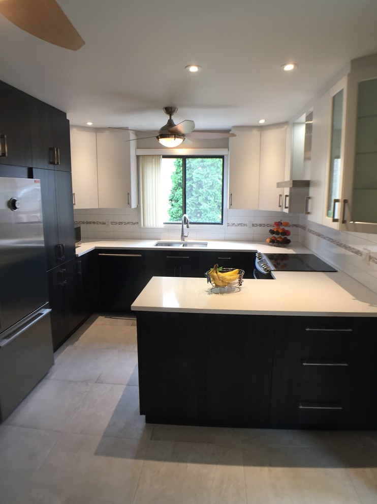 This is an example of a small modern u-shaped kitchen/diner in Montreal with a double-bowl sink, flat-panel cabinets, white cabinets, quartz worktops, white splashback, ceramic splashback, stainless steel appliances, ceramic flooring, a breakfast bar, grey floors and white worktops.