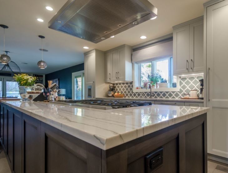 Example of a large transitional l-shaped cement tile floor and beige floor enclosed kitchen design in Denver with an undermount sink, recessed-panel cabinets, gray cabinets, marble countertops, multicolored backsplash, paneled appliances, an island and gray countertops
