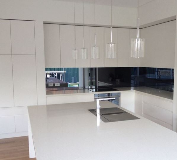 Example of a trendy l-shaped eat-in kitchen design in Sydney with an undermount sink, flat-panel cabinets, white cabinets, quartz countertops and stainless steel appliances